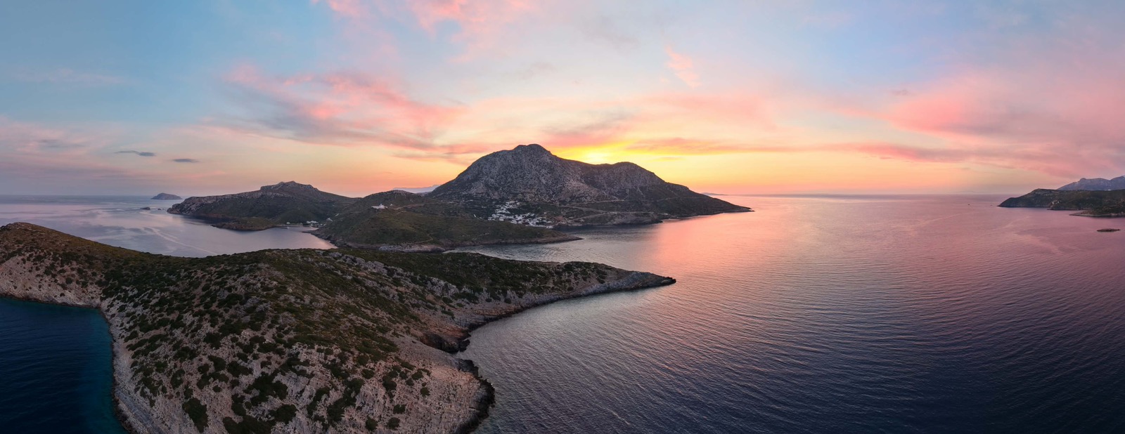 Άνθρωποι στο λιμάνι των Φούρνων Κορσεών με τη Θύμαινα στο βάθος